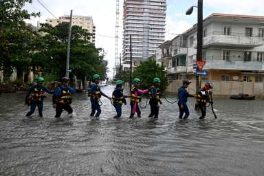 Rescue workers walk on a flooded street in Havana, Cuba Feb. 1, 2026.