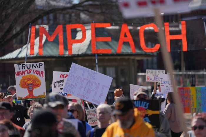 Demonstrators hold signs during the March4Democracy rally and march in Washington D.C., U.S., February 28, 2026.