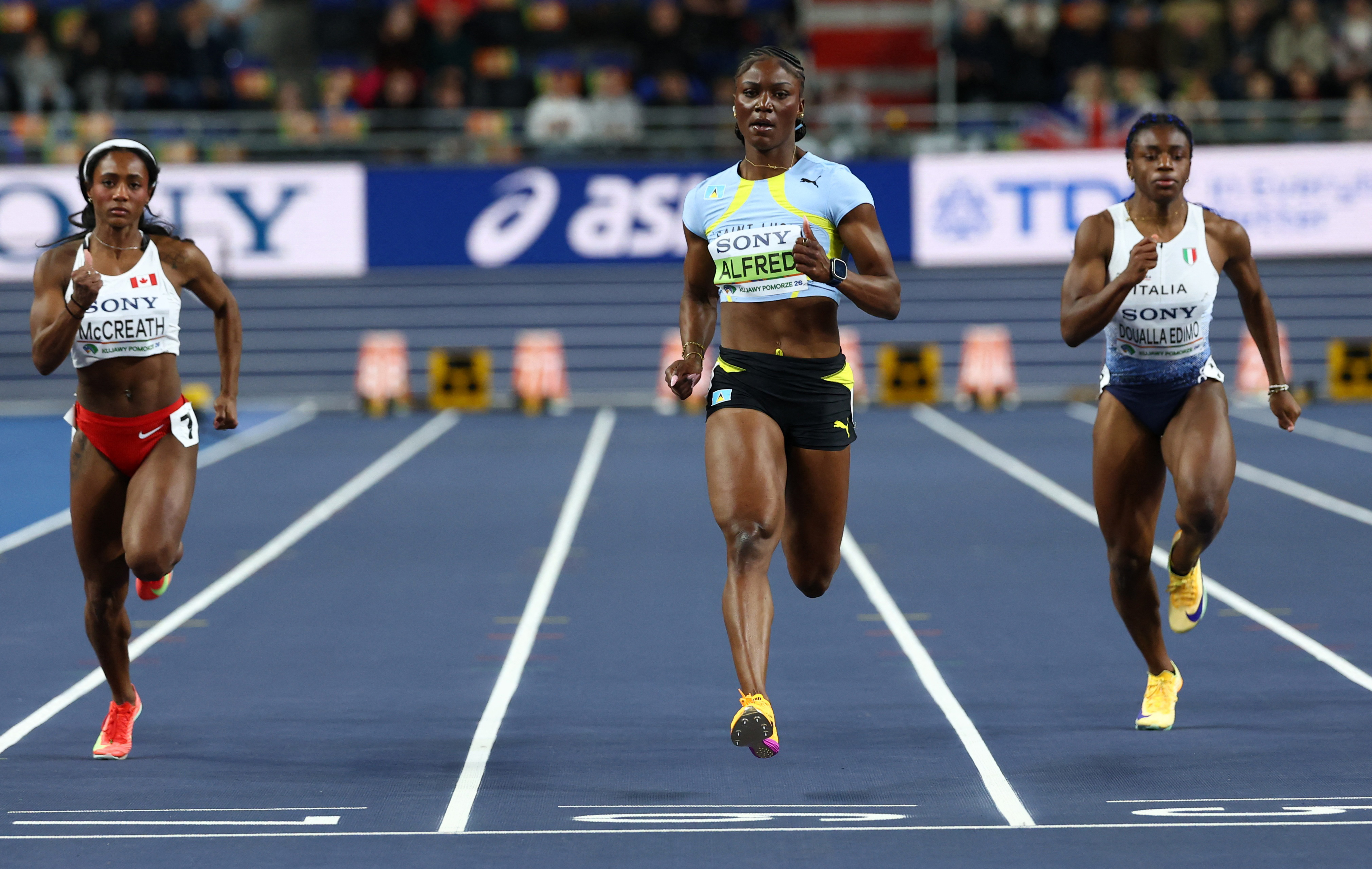 Saint Lucia's Julien Alfred crosses the line to win heat 4 of the women's 60m at the World Indoor Championships - Kujawsko-Pomorska Arena, Torun, Poland - March 21, 2026.