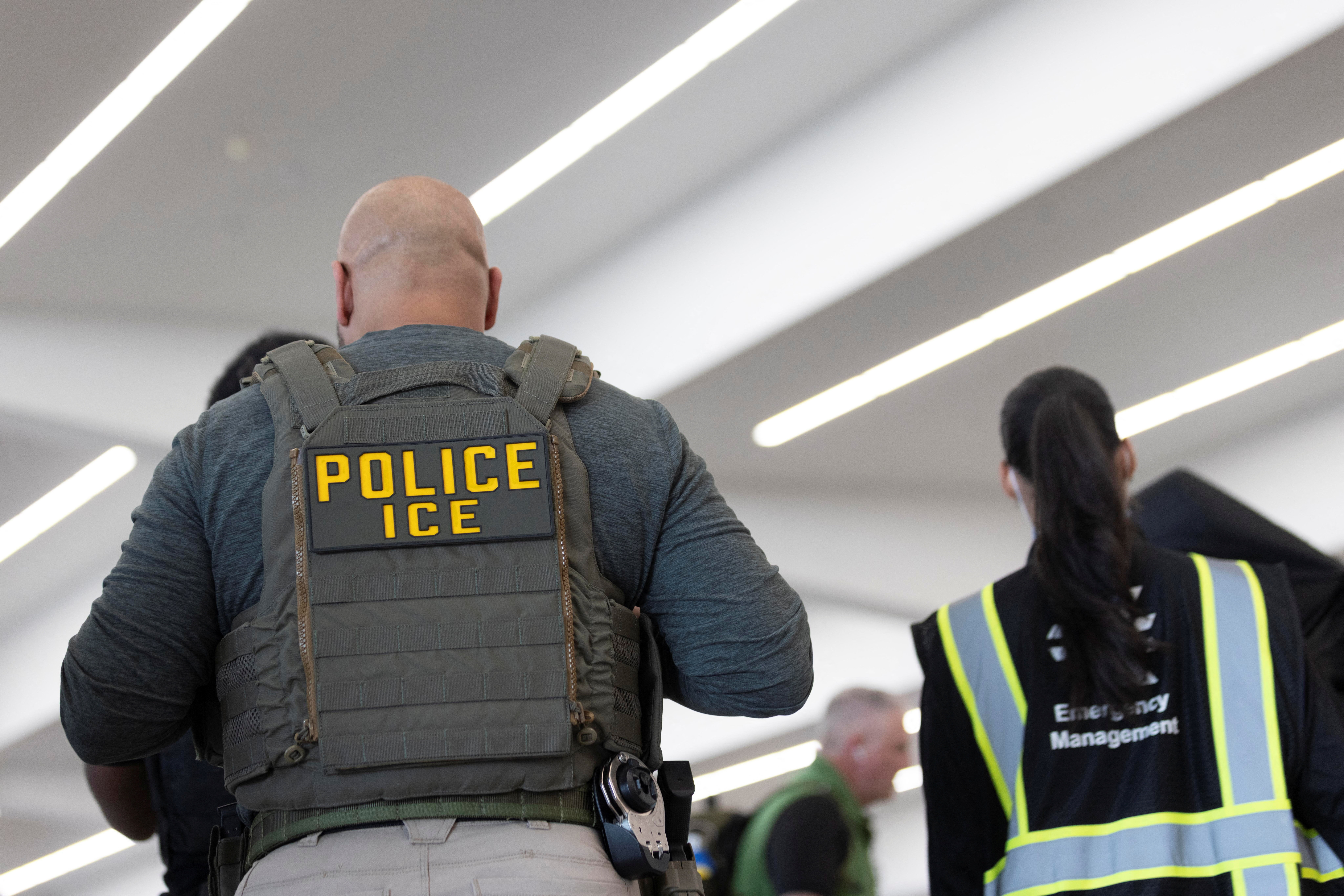 United States Immigration and Customs Enforcement (ICE) agents are present as passengers wait in line at a Transportation Security Administration (TSA) checkpoint after hundreds of Immigration and Customs Enforcement agents were ordered to deploy to airports to help fill TSA staffing gaps, at Hartsfield-Jackson Atlanta International Airport in Atlanta, Georgia, U.S. March 23, 2026.