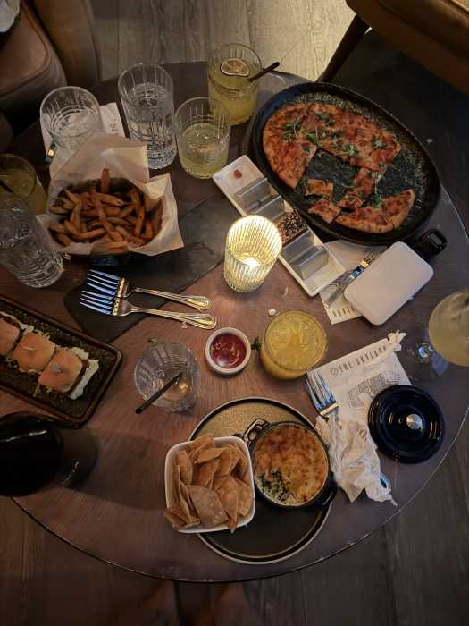 A selection of small bites and cocktails at The Skylark in Manhattan, where dishes like lobster mac and cheese, shrimp dumplings and tuna tacos pair with curated drinks to create a refined rooftop dining experience