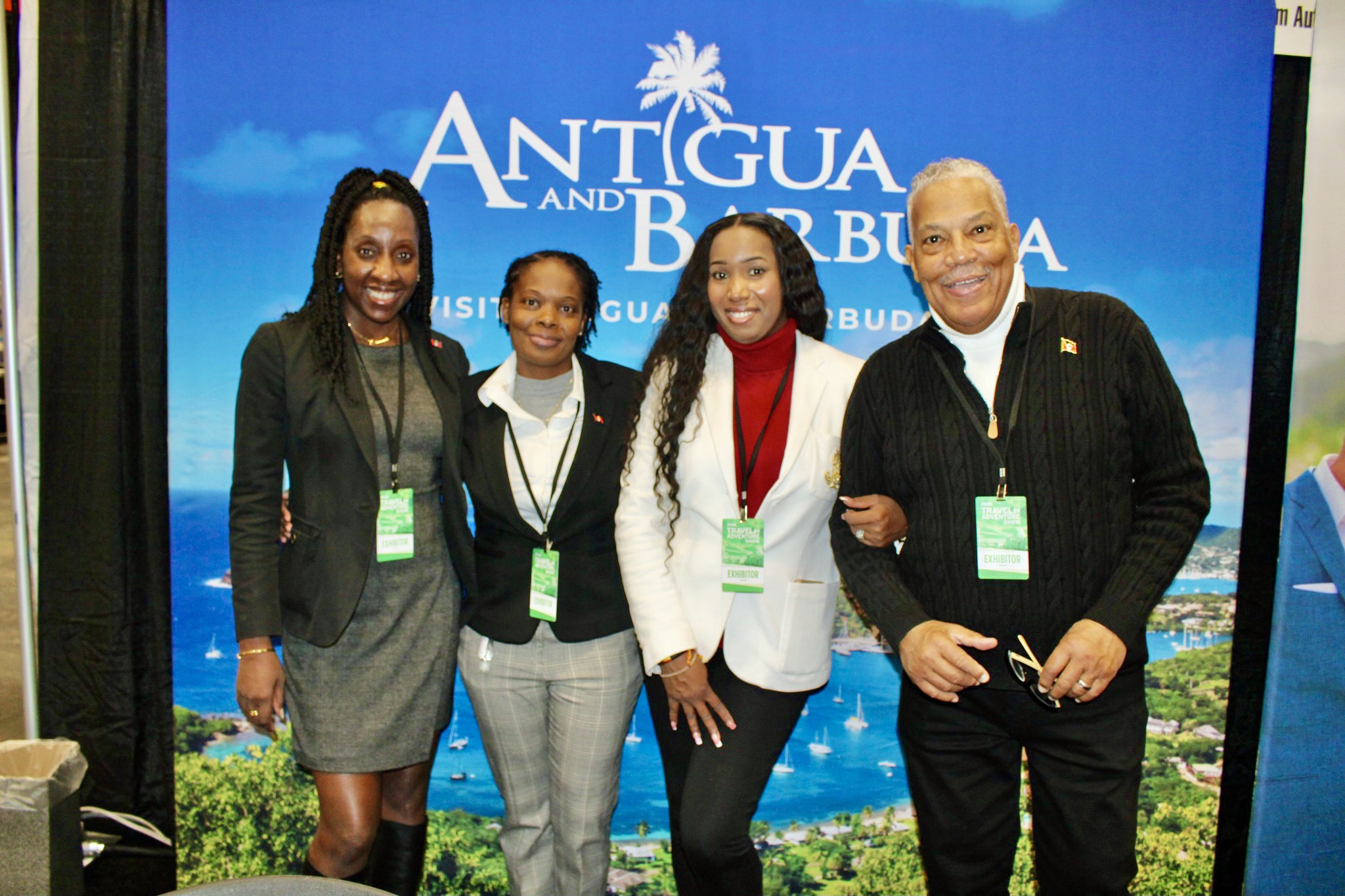 Antigua and Barbuda Tourism Authority eagerly chatted about their breathtaking island nation in the Eastern Caribbean, during the New York Travel & Adventure show, at the Jacob Javits Center in Manhattan on Jan. 24, 2026. From left are Canesha Appleton, Independent Travel Agent Kerryann Thomas, (Intele Travel) Colien Hinds, and Roderick HInds, at the Antigua and Barbuda kios against beautiful scenery of the twin-island state.