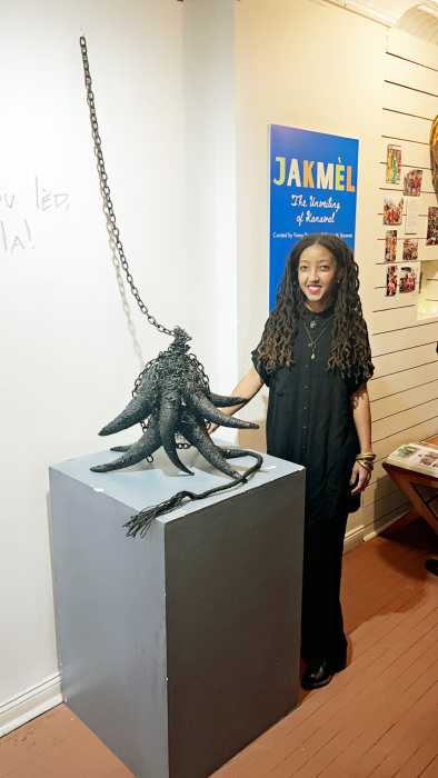 Tania L. Balan-Gaubert stands in front of her piece, featuring a cow horn.