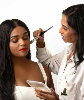 Priya Permaul Thomas applies makeup to a client during a demonstration, emphasizing the brand’s focus on mature skin and precise color matching.