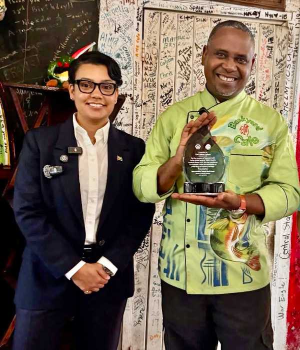 Minister of Tourism, Industry and Commerce Susan Rodrigues, left, presented Chef Delven Adams, proprietor of the Backyard Cafe in Georgetown, with a plaque in recognition of being listed as one of Time Magazine’s 2026 greatest places on the planet to visit.