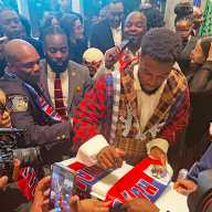 Duckens Nazon signs a Haitian flag at the Museum of Contemporary African Diasporan Arts (MoCADA) Gallery + Café in Brooklyn during “A Night for Haiti” event on April 13, 2026.