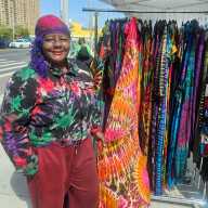 Sandra, creative owner of the San Jules Tie Dye brand shows off her collection of clothing, handbags, Tees, and Jewelry during Saturday, April 18, Little Caribbean and I Am CaribBeing marketplace at the intersection of Washington Avenue and Empire Boulevard in Brooklyn.