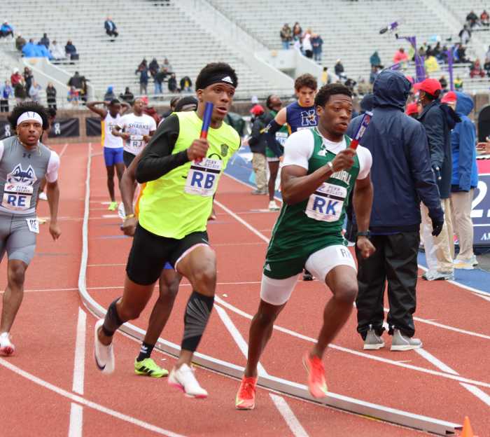 Serani Roban, RB, second from left, comes around the band, anchoring the 4x400m for the Grammar School.