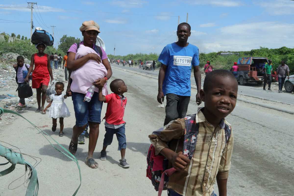 Residents walk along a street while fleeing their homes in Cite Soleil after rival gang clashes in Haiti's capital worsened over the weekend, in Port-au-Prince, Haiti, May 11, 2026.