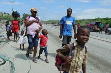 Residents walk along a street while fleeing their homes in Cite Soleil after rival gang clashes in Haiti's capital worsened over the weekend, in Port-au-Prince, Haiti, May 11, 2026.
