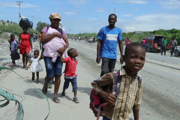 Residents walk along a street while fleeing their homes in Cite Soleil after rival gang clashes in Haiti's capital worsened over the weekend, in Port-au-Prince, Haiti, May 11, 2026.