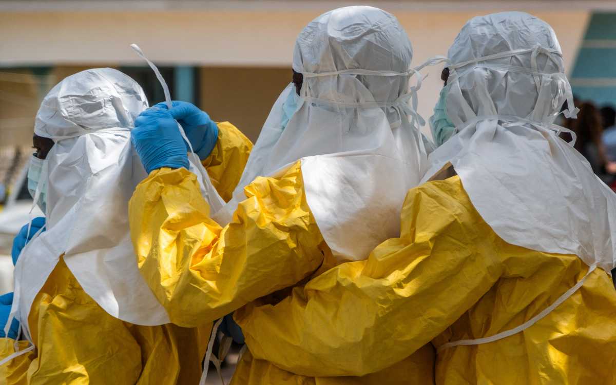 Red Cross workers wear personal protective equipment (PPE) before handling the body of Dr Tibenderana Katho Blaise, who worked at the Centre Medical Evangelique (CME) in Hoho commune and died of Ebola virus, as aid agencies intensify efforts to contain a new Ebola outbreak caused by the Bundibugyo virus, ahead of his burial in Bunia town, Ituri province, Democratic Republic of Congo, May 26, 2026.