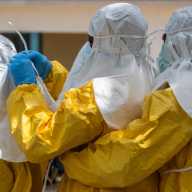Red Cross workers wear personal protective equipment (PPE) before handling the body of Dr Tibenderana Katho Blaise, who worked at the Centre Medical Evangelique (CME) in Hoho commune and died of Ebola virus, as aid agencies intensify efforts to contain a new Ebola outbreak caused by the Bundibugyo virus, ahead of his burial in Bunia town, Ituri province, Democratic Republic of Congo, May 26, 2026.
