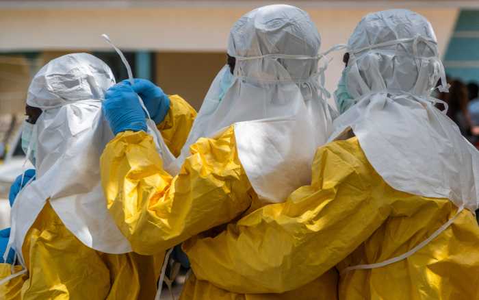 Red Cross workers wear personal protective equipment (PPE) before handling the body of Dr Tibenderana Katho Blaise, who worked at the Centre Medical Evangelique (CME) in Hoho commune and died of Ebola virus, as aid agencies intensify efforts to contain a new Ebola outbreak caused by the Bundibugyo virus, ahead of his burial in Bunia town, Ituri province, Democratic Republic of Congo, May 26, 2026.