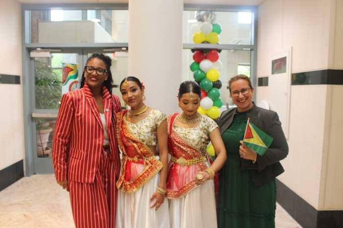 Deputy Queens Borough President Ebony Young, left, and Deputy Mayor for Health and Human Services Dr. Helen Arteaga-Landaverde, far right, with members of Dharmic Nritya Sangh dancers in the Helen Marshall Cultural Centre, Queens Borough Hall, on May 26, 2026, at Guyana's 60th Independence Anniversary commemoration.