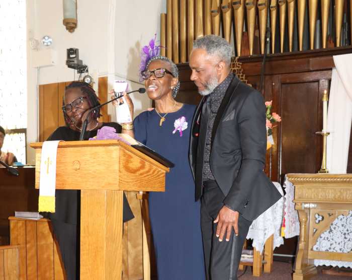 Marlene Ferguson, Marva Sobers's sister, eulogizes her, flanked by Carmelo Joseph, Marva's son-in-law, and daughter, Karla, left.