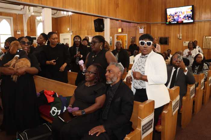 Karla Joseph and husband, Carmelo Joseph, in front pew, right, with mourners.
