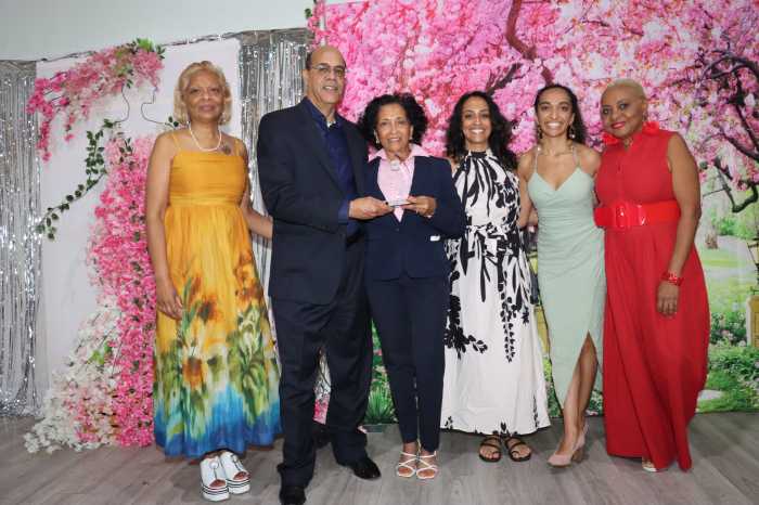 Dr. Jacqueline Gaymes-Jones, third from left, holds a plaque with her husband, Dr. Sivi Jones, flanked by family members and GHS Alumni Treasurer Maxine Mayers, right.