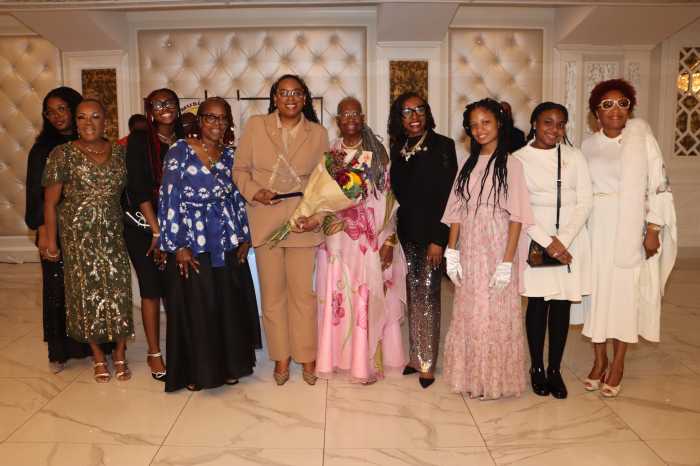 New Jersey Congresswoman LaMonica McIver holds a plaque, flanked by PDPA President Bishop Sylveta Hamilton-Gonzales, holding bouquet of flowers; Congresswoman Yvette D. Clarke, fourth from right; Brooklyn Council Member Mercedes Narcisse, right; and other members of PDPA.