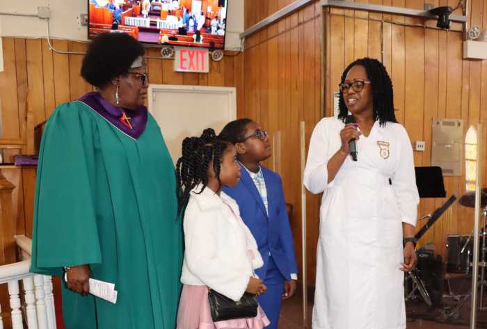 Valcia Williams gives an acceptance speech as her children look on: son, Nicholas Charles, and daughter, Noelani Charles.