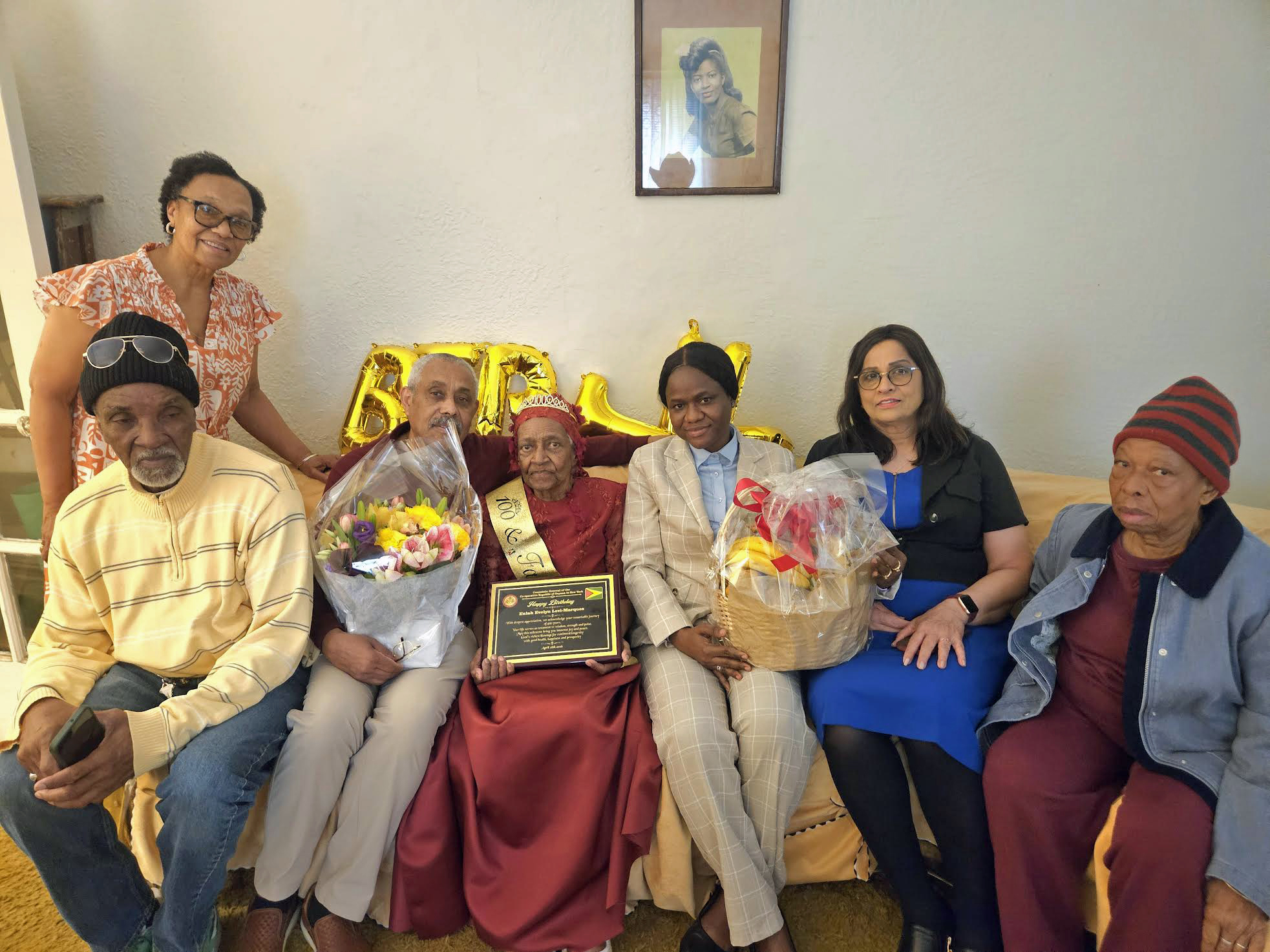 Family members from left, sitting, nephew Linden Levi, Son Jermone Serrao, Mrs. Eulah Evelyn Levi-Marque, Consulate staffers, Nacifa Watson, and Fazia Khusial, a family friend, and standing, Daughter-in-law, Judy Boyce-Serrao.