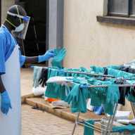 A Ugandan worker collects a rubber glove from the airing line during a visit by the Director-General of the World Health Organisation (WHO) Tedros Adhanom Ghebreyesus at the Mulago National Referral Hospital Isolation Unit, as aid agencies intensify efforts to contain a new Ebola outbreak involving the Bundibugyo Virus, in Mulago suburb, of Kampala, Uganda, June 8, 2026.