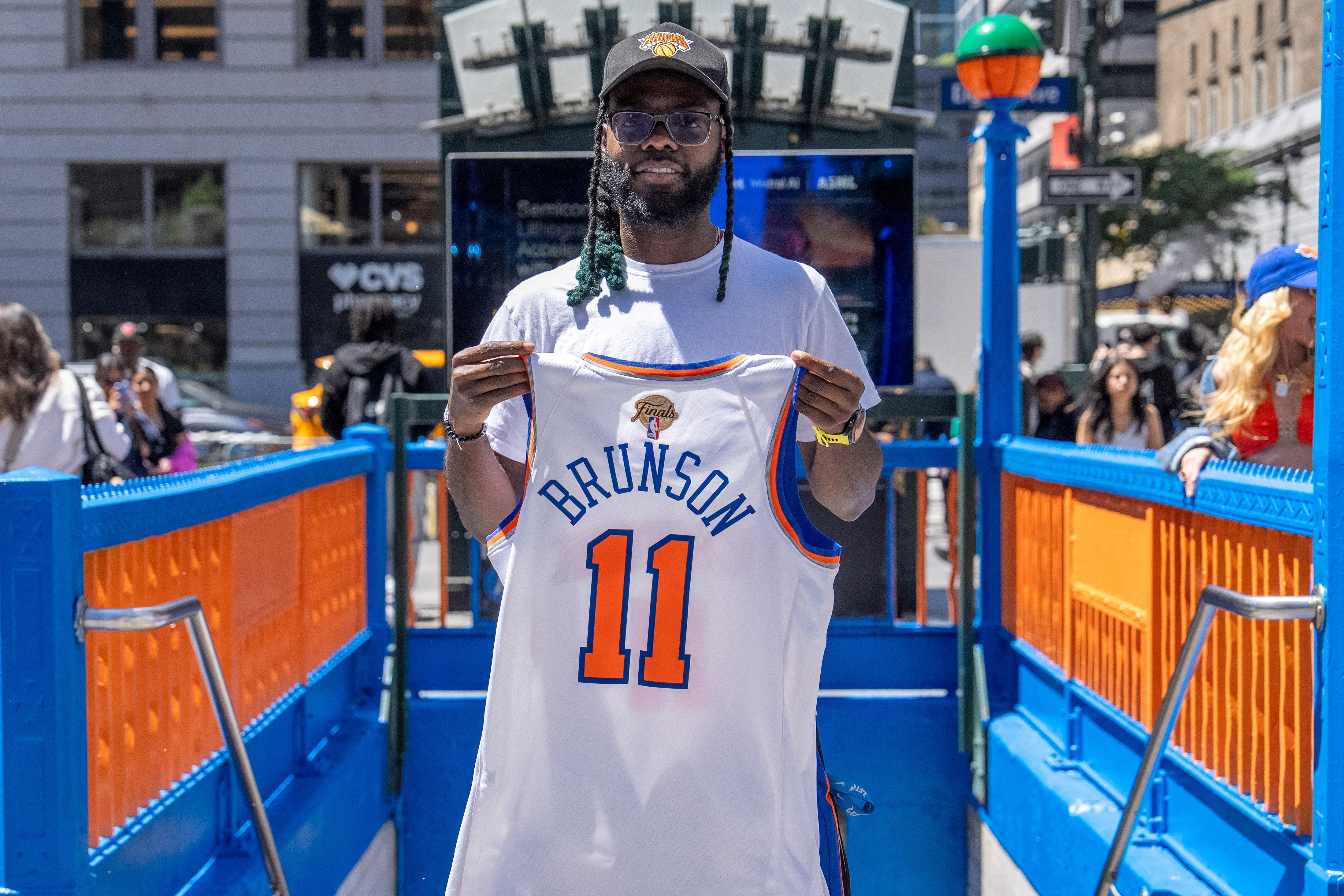 A New York Knicks fan poses at the 34th Street Penn Station subway entrance after the Metropolitan Transit Authority (MTA) painted it in orange and blue in honor of the hometown team's first championship finals in 27 years, in New York City, U.S., June 2, 2026.