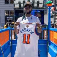A New York Knicks fan poses at the 34th Street Penn Station subway entrance after the Metropolitan Transit Authority (MTA) painted it in orange and blue in honor of the hometown team's first championship finals in 27 years, in New York City, U.S., June 2, 2026.