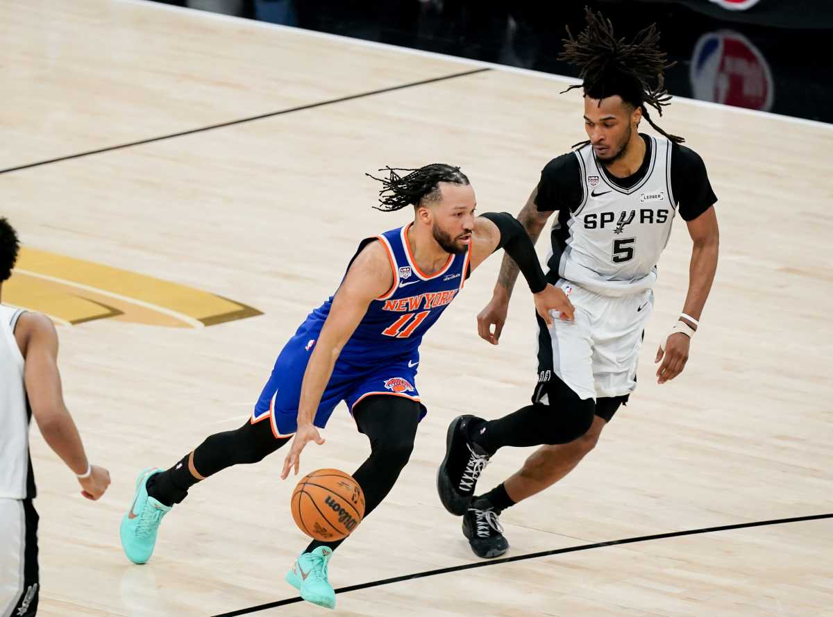 New York Knicks guard Jalen Brunson (11) dribbles against San Antonio Spurs guard Stephon Castle (5) in the second half during game five of the 2026 NBA Finals at Frost Bank Center.