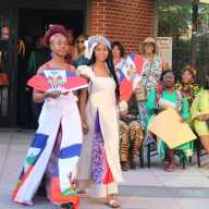 Models wearing colorful designs from AJYI Variety Store during a June 4 Afro-Caribbean fashion show on the Dorothy L. Goosby Plaza in celebration of Caribbean Heritage at Hempstead Town Hall. Other colorfully dressed audience members look on.