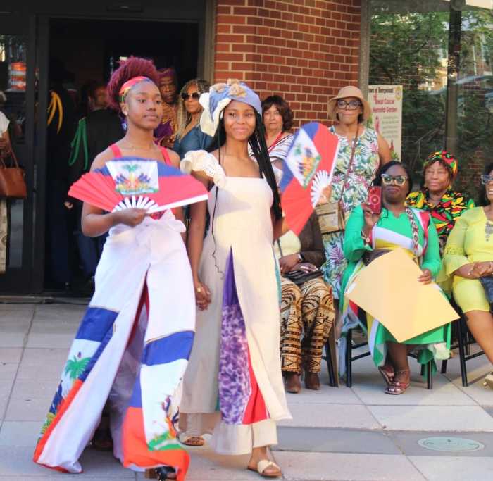 Models wearing colorful designs from AJYI Variety Store during a June 4 Afro-Caribbean fashion show on the Dorothy L. Goosby Plaza in celebration of Caribbean Heritage at Hempstead Town Hall. Other colorfully dressed audience members look on.
