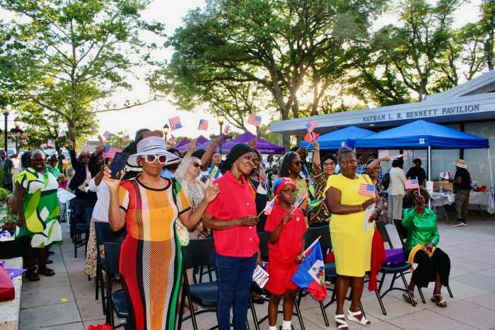 A colorfully dressed audience waves the Stars and Stripes American flag during a tribute to the 250th independence anniversary segment at an annual Caribbean American Heritage commemoration on the Dorothy Goosby Plaza at Hempstead Town Hall on June 4.